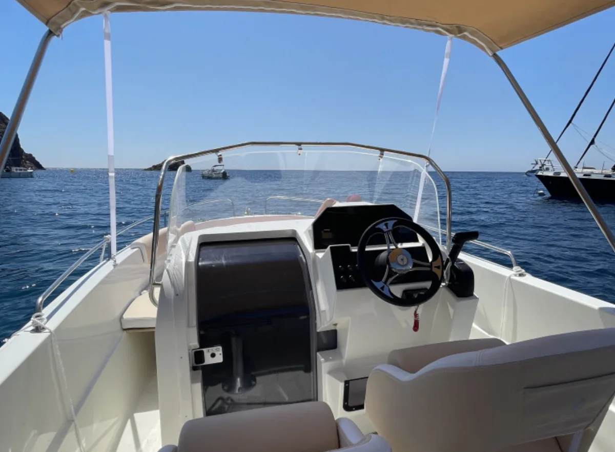 Boat console navigating a Costa Brava cove